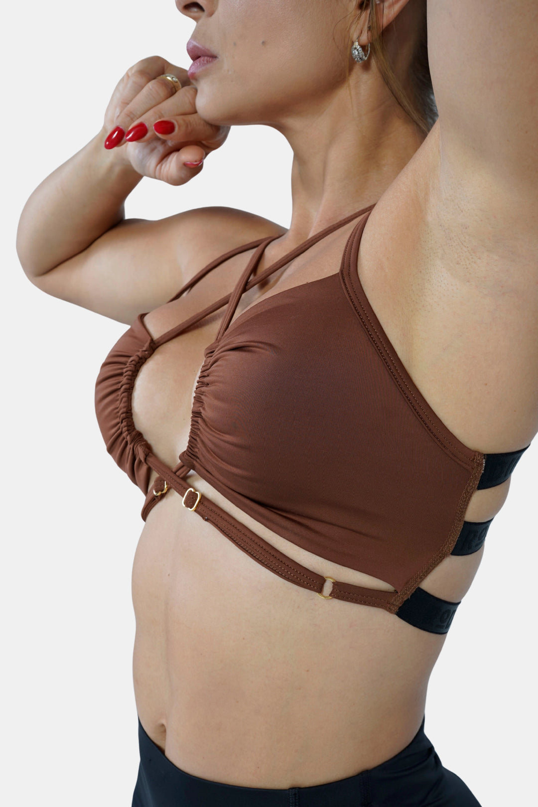 Woman wearing a brown bikini top with black straps on a white background #color_cappuccino