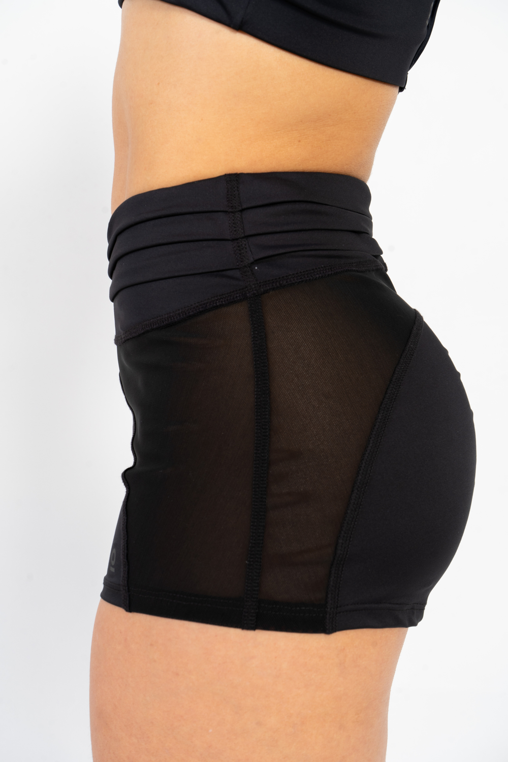 Black athletic shorts with mesh panels on a white background #color_black