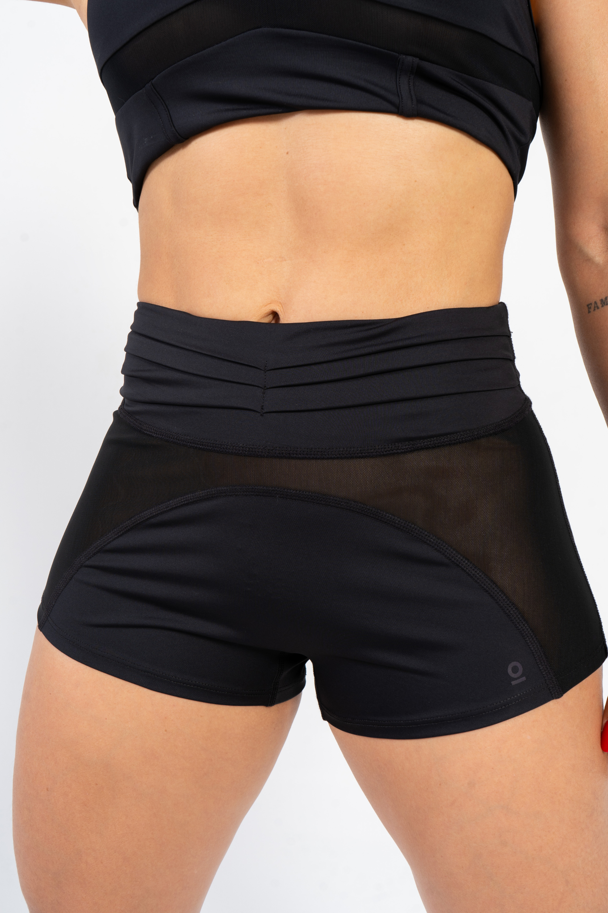 Person wearing black athletic shorts and top on a light gray background #color_black