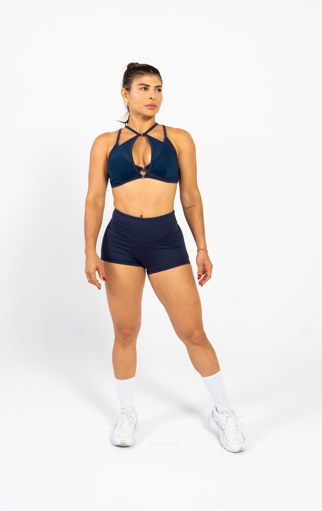 Woman wearing a navy sports bra and shorts set on a white background #color_dark-iris
