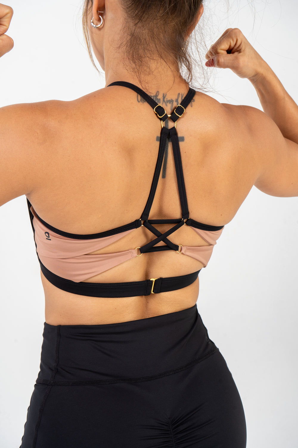 Person wearing a strappy top with a white background