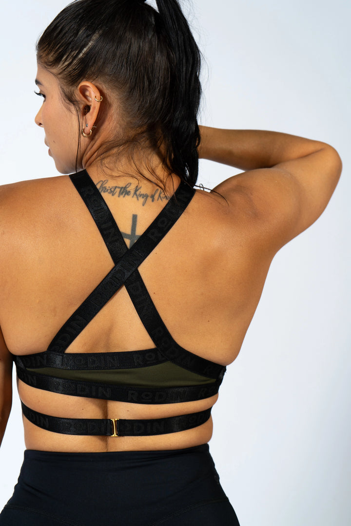 Person wearing a black sports bra with criss-cross straps 
color riffle green#color_riffle-green