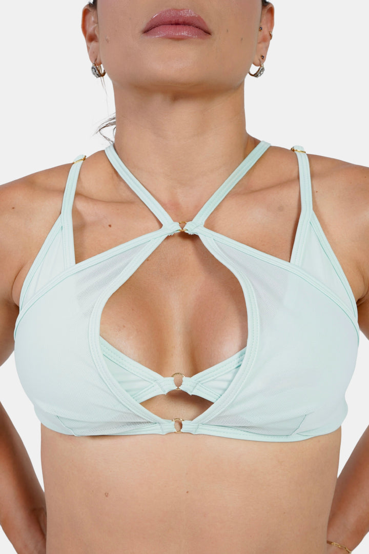 Light green sports bra worn by a model on a white background #color_mint