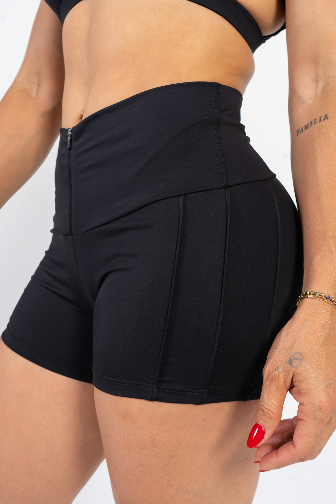 Person wearing black athletic shorts on a plain background 
