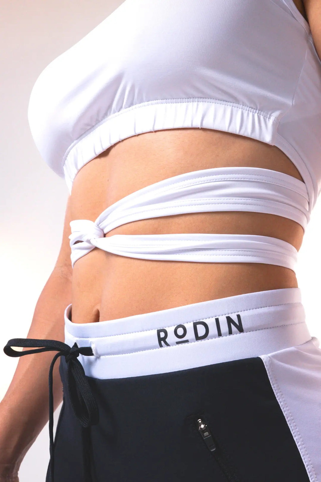 Woman wearing the Nikkie crop top functional of color white#color_white