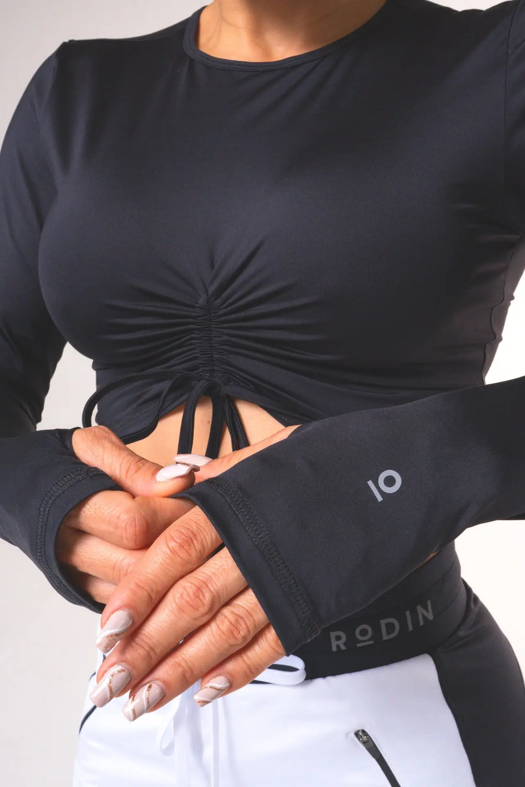 Woman wearing the Shasta functional long of sleeve scrunch top and color black#color_black